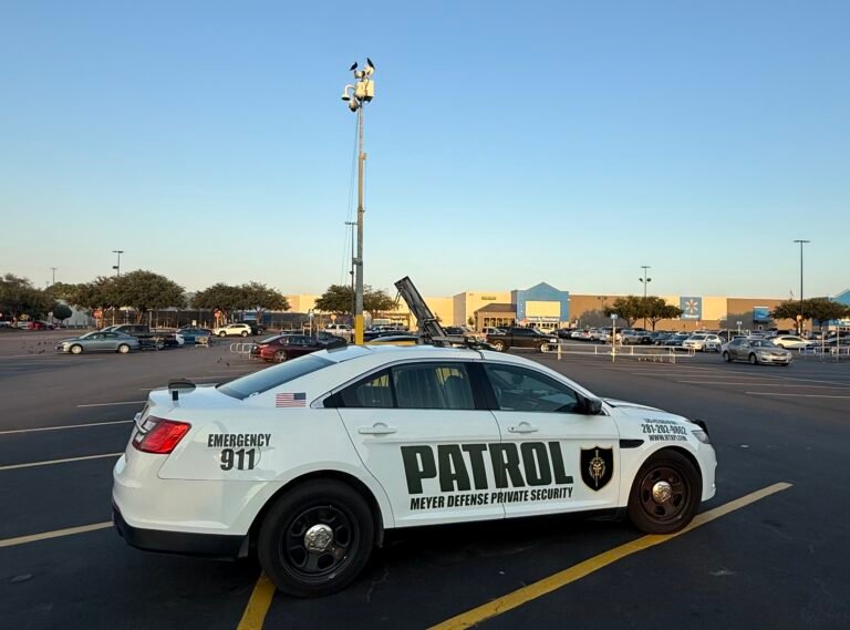 Security patrol vehicle from Mayer Security Services in a parking lot, featuring emergency contact details and surveillance equipment, emphasizing property protection in Houston.